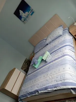 a bed with a box and two towels on it at Apartman Miki Jovanović in Pirot