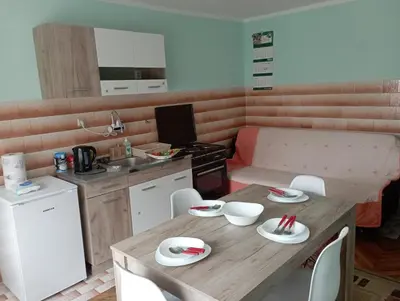 a small kitchen with a wooden table and chairs at Apartman Miki Jovanović in Pirot