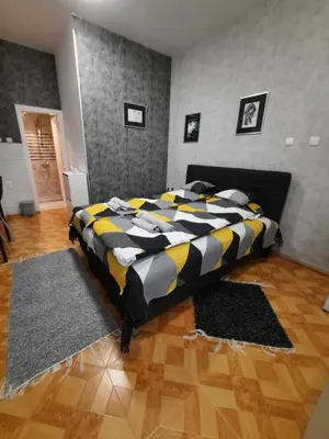 a bedroom with a bed with a black and yellow blanket at Apartman STEVAN Vrnjačka Banja in Vrnjačka Banja