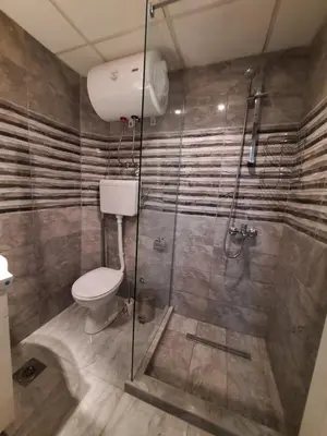 a bathroom with a toilet and a glass shower at Apartman STEVAN Vrnjačka Banja in Vrnjačka Banja