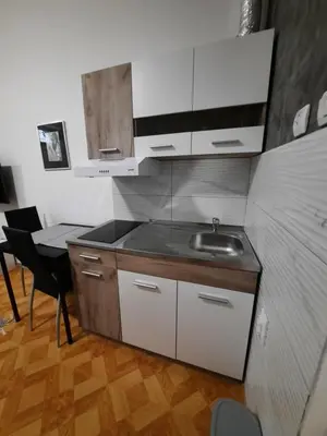 a kitchen with a sink and a table with a chair at Apartman STEVAN Vrnjačka Banja in Vrnjačka Banja