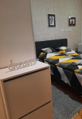 a bedroom with a bed with a black and yellow blanket at Apartman STEVAN Vrnjačka Banja in Vrnjačka Banja