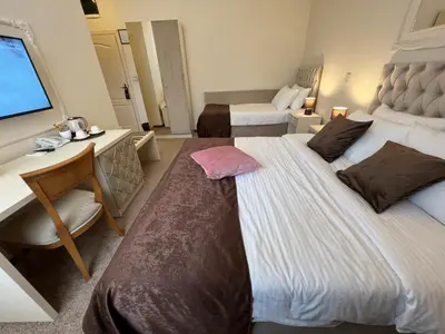 a hotel room with two beds and a desk and a television at International Inn in Paraćin