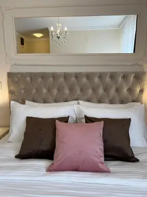 a bed with two pillows and a large headboard at International Inn in Paraćin