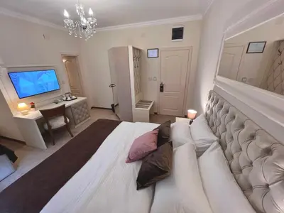 a large white bedroom with a large bed and a desk at International Inn in Paraćin