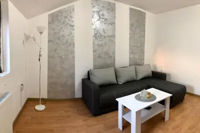 a living room with a black couch and a table at Lovely 1-bedroom condo with available parking in Kraljevo