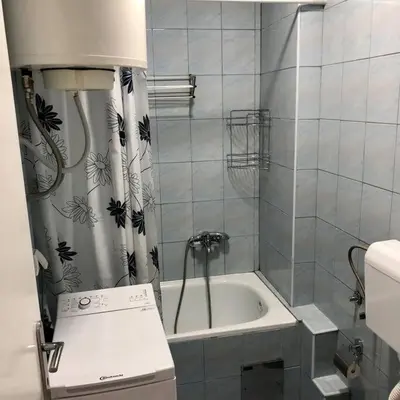 a small bathroom with a tub and a sink at Lovely 1-bedroom condo with available parking in Kraljevo