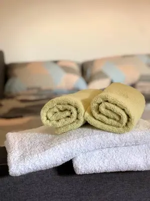 a pile of towels sitting on top of a bed at Lovely 1-bedroom condo with available parking in Kraljevo