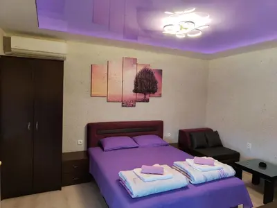 a bedroom with a purple bed with towels on it at Centrum Lux Apartment in Niš