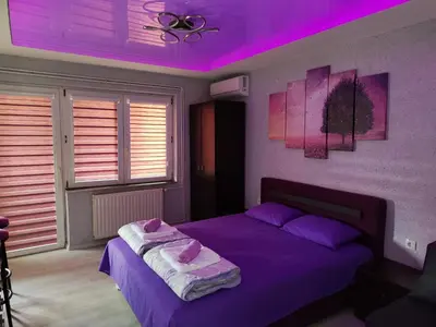 a bedroom with a purple ceiling and a bed at Centrum Lux Apartment in Niš