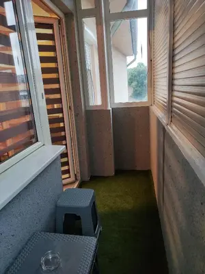 an empty room with a window and a stool at Centrum Lux Apartment in Niš