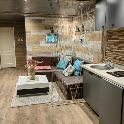 a kitchen with a couch and a sink in a room at Apartman OGLEDALO in Zaječar