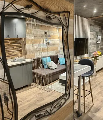 a kitchen and living room with a couch and a table at Apartman OGLEDALO in Zaječar