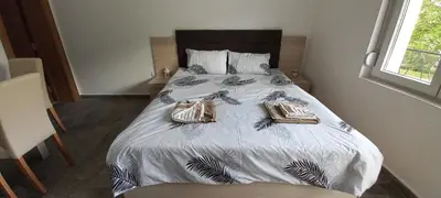a bedroom with a bed with two bags on it at Apartman Vista Sokobanja in Soko Banja
