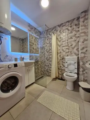 a bathroom with a washing machine and a toilet at Apartman Vista Sokobanja in Soko Banja