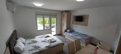 a bedroom with a bed and a table in it at Apartman Vista Sokobanja in Soko Banja