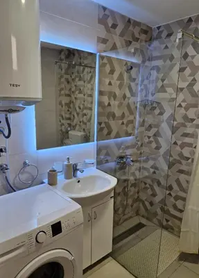 a bathroom with a sink and a washing machine at Apartman Vista Sokobanja in Soko Banja