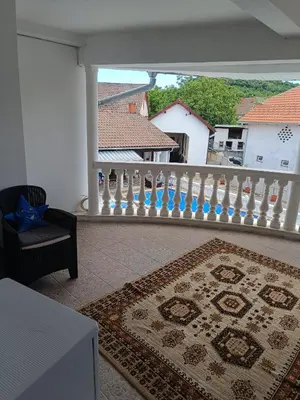 a balcony with a rug and a white railing at Vila Jovana A in Rogljevo