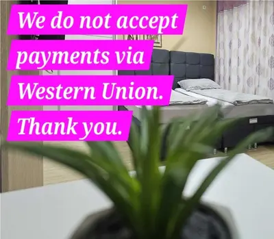 a pink sign in a room with a bed and a plant at Apartman LENI2 u centru Zajecara in Zaječar