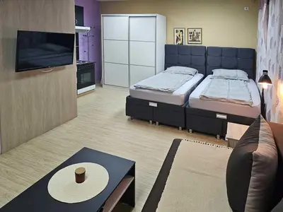 a bedroom with two beds and a flat screen tv at Apartman LENI2 u centru Zajecara in Zaječar
