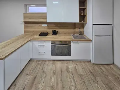 a kitchen with white appliances and a wooden floor at Apartman LENI2 u centru Zajecara in Zaječar