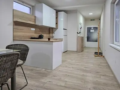 a kitchen with white cabinets and a table and chairs at Apartman LENI2 u centru Zajecara in Zaječar