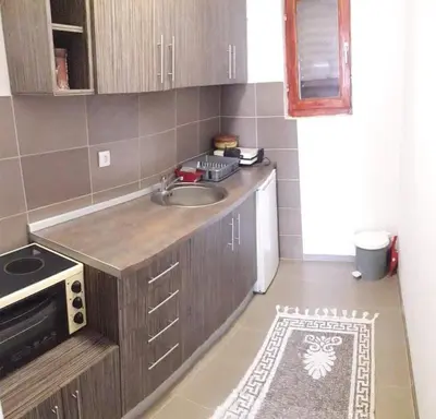 a small kitchen with a sink and a stove at Apartmani Damjan Vlasinsko jezero in Surdulica