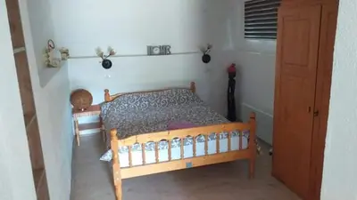 a bedroom with a wooden bed in a room at Apartmani Damjan Vlasinsko jezero in Surdulica