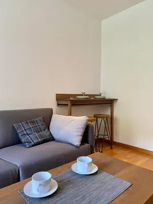 a living room with a couch and two cups on a table at Apartman 20, Brzeće Centar in Brzeće