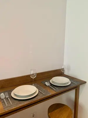 a table with two plates and wine glasses on it at Apartman 20, Brzeće Centar in Brzeće
