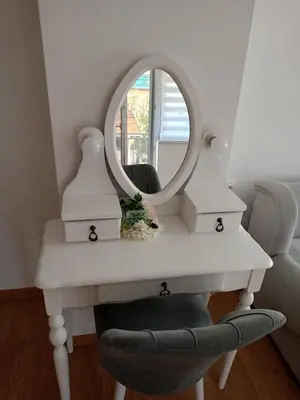 a dressing table with a mirror and a chair at Gostinska kuća in Leskovac