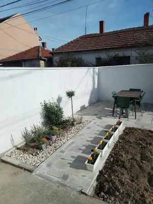 a patio with a table and some plants on it at Gostinska kuća in Leskovac