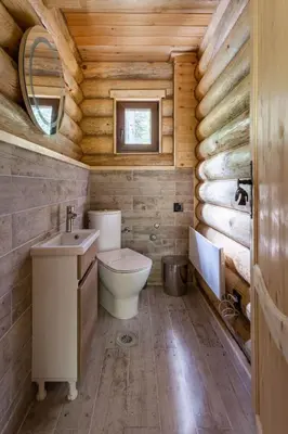 a bathroom with a toilet and a sink in a log cabin at Casa Montana in Kopaonik