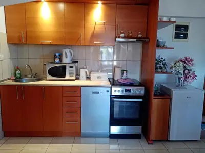 a kitchen with a stove and a microwave at Apartman Simović, Vrnjačka Banja in Vrnjačka Banja