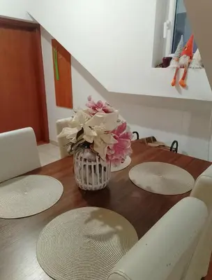 a dining room table with a vase of flowers on it at Apartman Simović, Vrnjačka Banja in Vrnjačka Banja