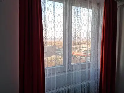a window with white curtains and a red curtain at CENTRAL in Kruševac