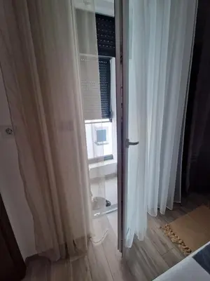 a room with white curtains and a window at apartman TARA aqua park in Jagodina
