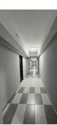 an empty hallway in a building with a checkered floor at apartman TARA aqua park in Jagodina