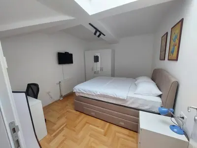 a bedroom with a bed and a television in it at Riverside apartment with private parking in Niš