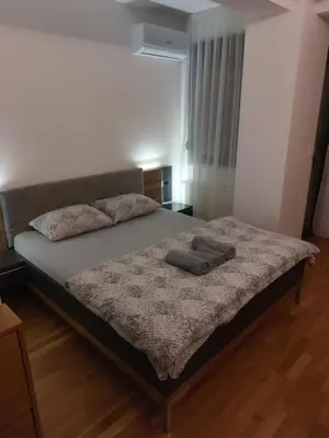 a bed with two pillows on it in a bedroom at Centar Crnjanski 1 in Jagodina