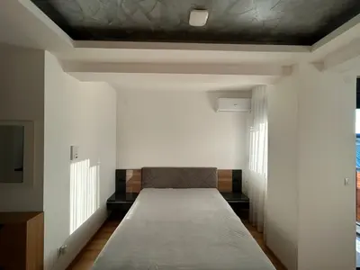 a bed in a room with white walls and a ceiling at Centar Crnjanski 1 in Jagodina