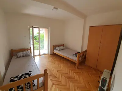 a bedroom with two beds and a large window at Big apartman - Free parking in Vranje