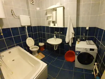 a blue tiled bathroom with a toilet and a sink at Big apartman - Free parking in Vranje