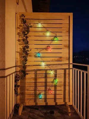 a fence with christmas lights on a balcony at Apartman HeLena in Soko Banja