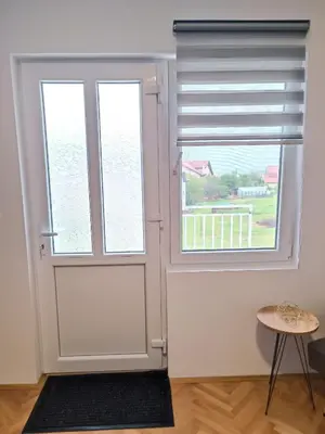 a room with a door and two windows at Apartman HeLena in Soko Banja