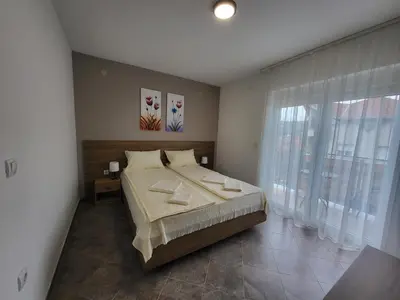 a bedroom with a bed and a large window at Vila Pčelica Petra in Soko Banja