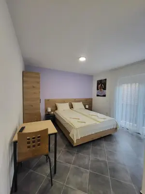 a bedroom with a large bed and a table at Vila Pčelica Petra in Soko Banja