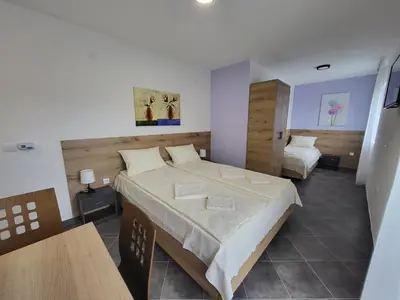 a hotel room with two beds and a table at Vila Pčelica Petra in Soko Banja