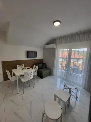a living room with a table and chairs and a couch at Vila Pčelica Petra in Soko Banja