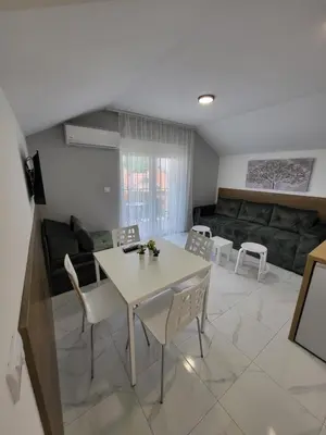 a living room with a table and chairs and a couch at Vila Pčelica Petra in Soko Banja